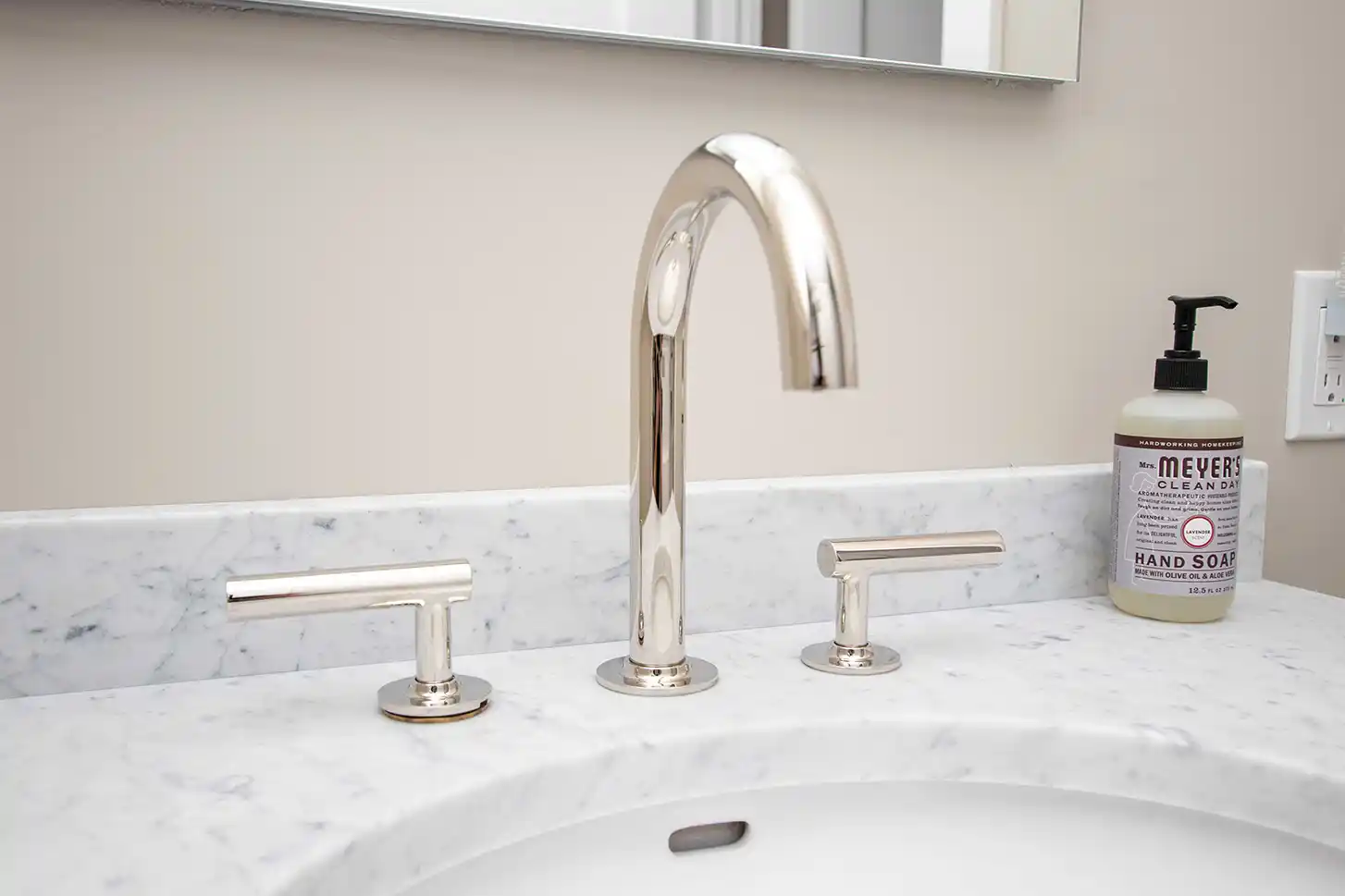 Polished faucet and fixtures on a marble bathroom counter