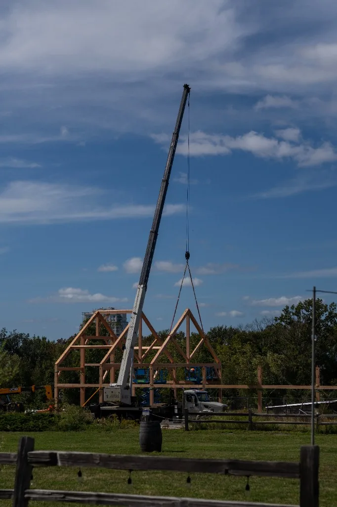 Crane raising timber framing against a blue sky at Ragged Island